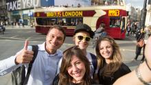 Students doing a selfie in front a bus in london