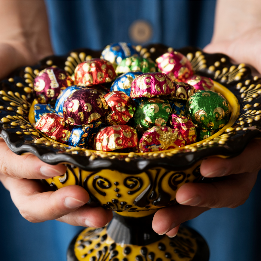 Colorful coated candies in hand-held glass bowl