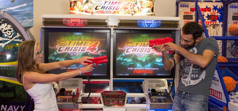 two students playing in a video game center