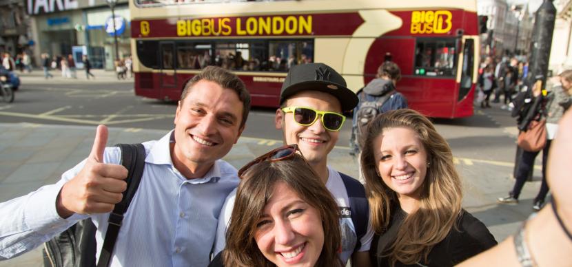 Students doing a selfie in front a bus in london