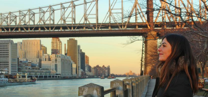 girl looking at the river with a bridge behind