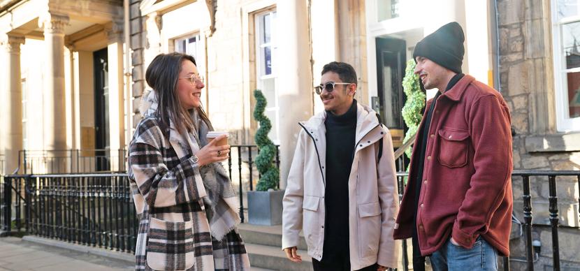 3 students talking together in the street