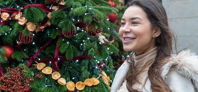 student in front of christmas tree