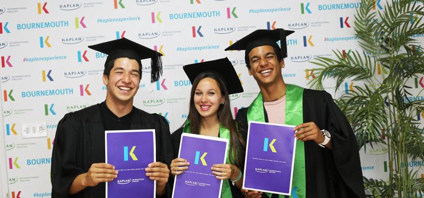 3 kaplan students showing their diplomas