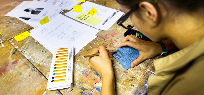 Student doing art on a table