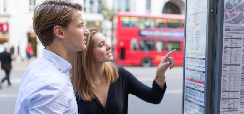 students looking at bus timetable in London