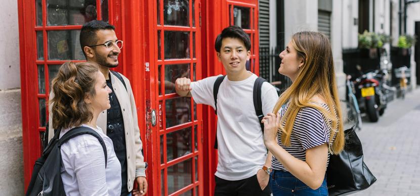 students talking together next to an english phone booth