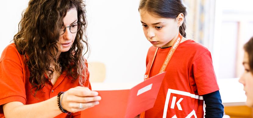 teacher and students looking at a book