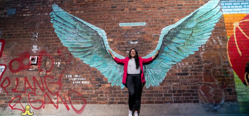 student with wings on a wall on the back