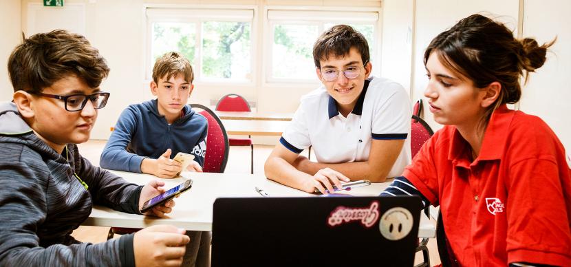 students and teacher looking at a screen