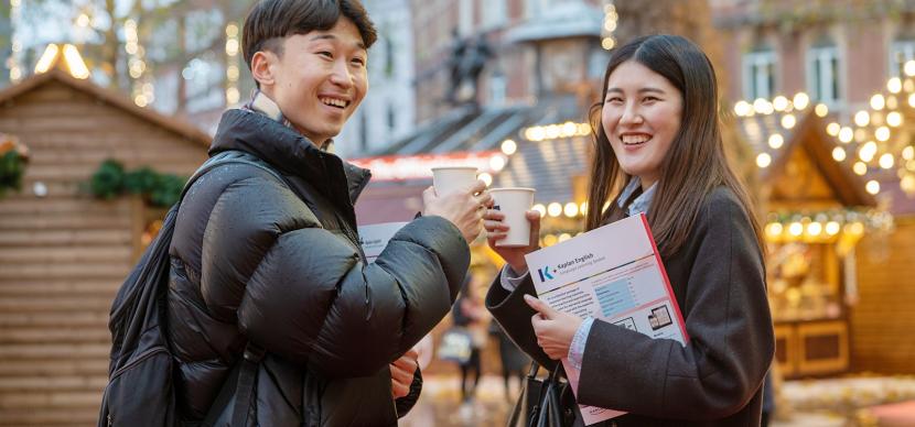 two students having a drink in the christmas market