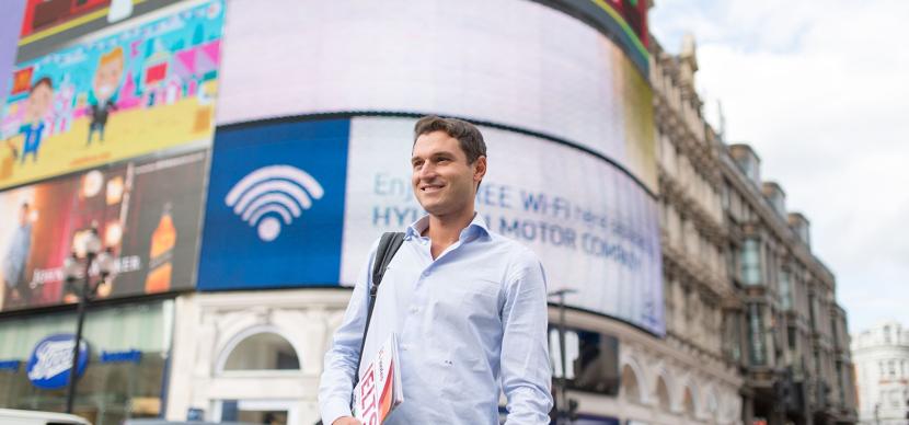 Student holding a brochure in picadilly circus