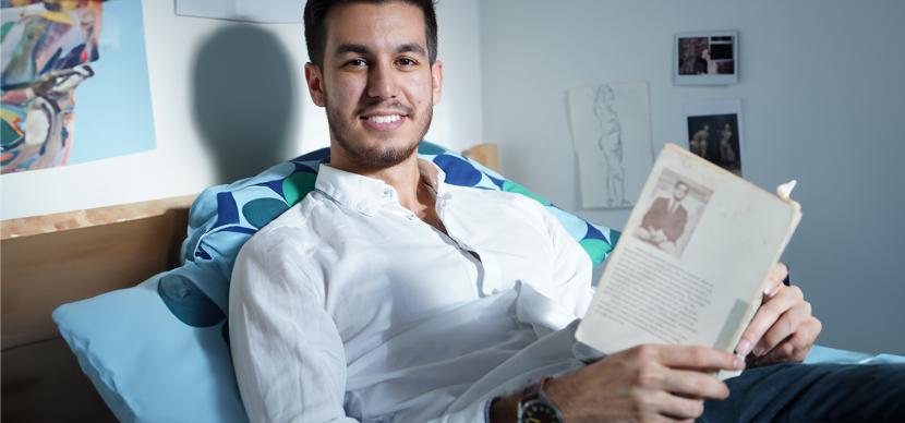 student reading his book in bed