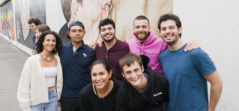 students smiling in front of wall berlin