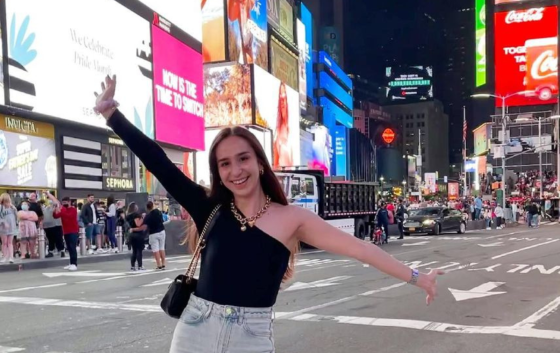 Girl, arms wide, standing in Times Square