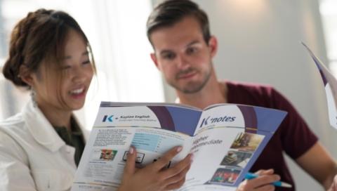 Students holding a Kaplan book