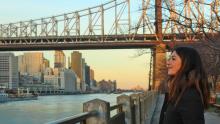 girl looking at the river with a bridge behind