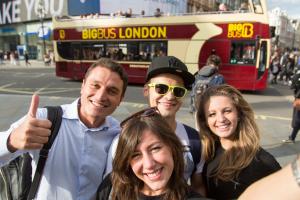 Students doing a selfie in front a bus in london