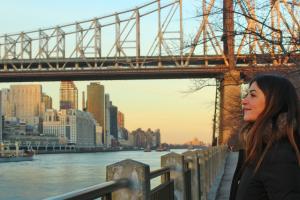 girl looking at the river with a bridge behind