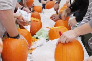 students carving pumpkin