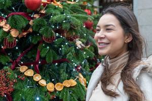 student in front of christmas tree