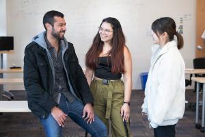 3 students talking together in classroom