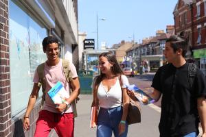 3 students talking together in the street