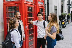 students talking together next to an english phone booth