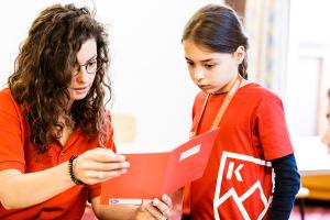 teacher and students looking at a book