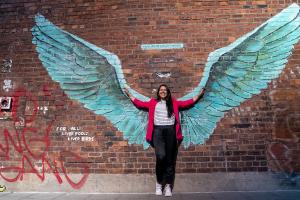 student with wings on a wall on the back