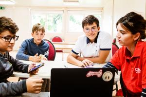 students and teacher looking at a screen