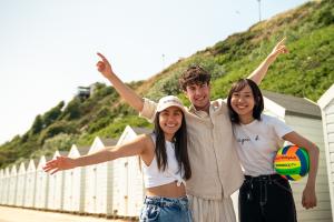 3 students on a beach in bournemouth