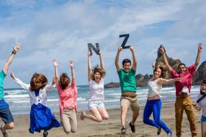 students jumping at a beach