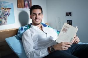 student reading his book in bed