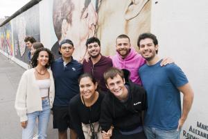 students smiling in front of wall berlin