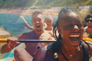 Young adults having fun doing rafting