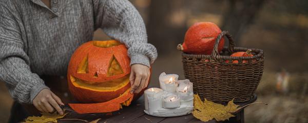 woman carving a halloween pumpkin