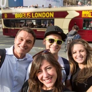 Students doing a selfie in front a bus in london
