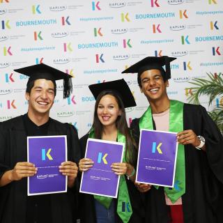 3 kaplan students showing their diplomas