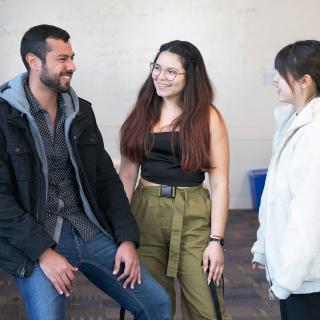 3 students talking together in classroom