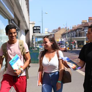 3 students talking together in the street