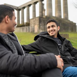 two students talking together on a bench