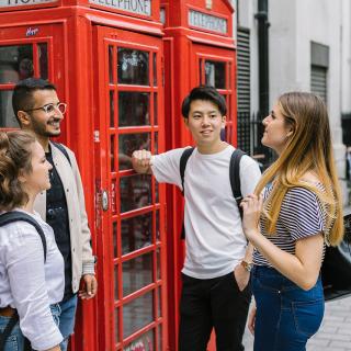 students talking together next to an english phone booth