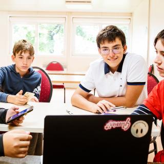 students and teacher looking at a screen