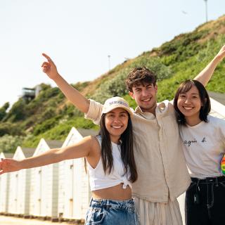 3 students on a beach in bournemouth