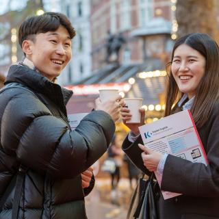 two students having a drink in the christmas market