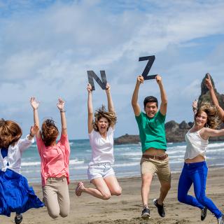 students jumping at a beach