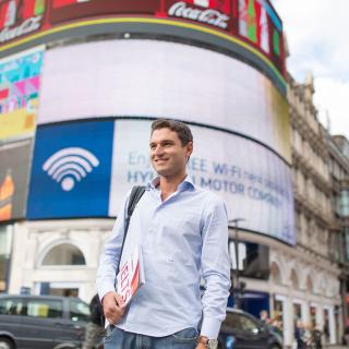 Student holding a brochure in picadilly circus