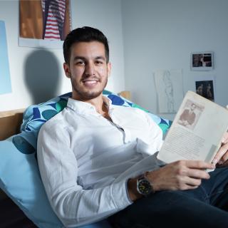 student reading his book in bed