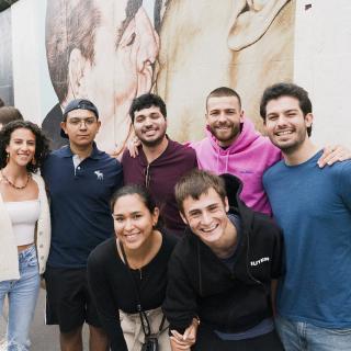 students smiling in front of wall berlin